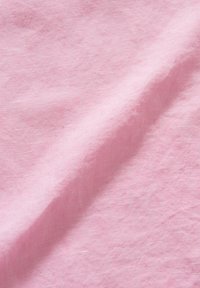 Tessuto di lino rosa con una superficie morbida e texture, caratterizzato da sottili variazioni di colore, che presenta una caduta leggera e traspirante.