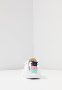 White canvas sneaker with lace-up front and embroidered back design in blue, pink, and light green. Flat sole, minimalistic style.