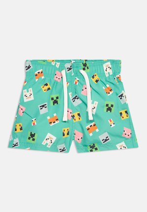 Barnebadetøy i grønnblå med hvit snor og fargerike pixelerte dyreansikter trykt over hele.