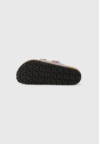 Cork footbed sandals with a pink upper, dual adjustable straps, and a textured black rubber sole featuring a wave pattern for grip.