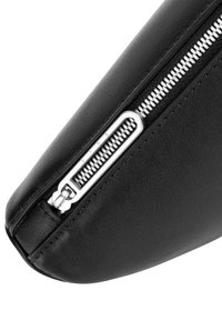Schwarze Lederetui mit glatter Textur, ausgestattet mit einem silbernen Reißverschluss und metallischen Beschlägen entlang der oberen Naht.