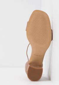 Sandale marron pour femme avec bout carré et talon bloc, vue de la semelle montrant la marque ALDO et un motif texturé antidérapant.
