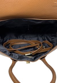 Brązowa torba skórzana o fakturze, z czarnym wnętrzem, z dwoma uchwytami i regulowanym paskiem na ramię, zawierająca wewnętrzną kieszeń na zamek.