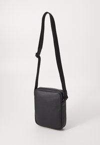 Borsa a tracolla nera in pelle con superficie testurizzata, forma rettangolare, tracolla regolabile e chiusura con zip superiore. Design compatto e funzionale.