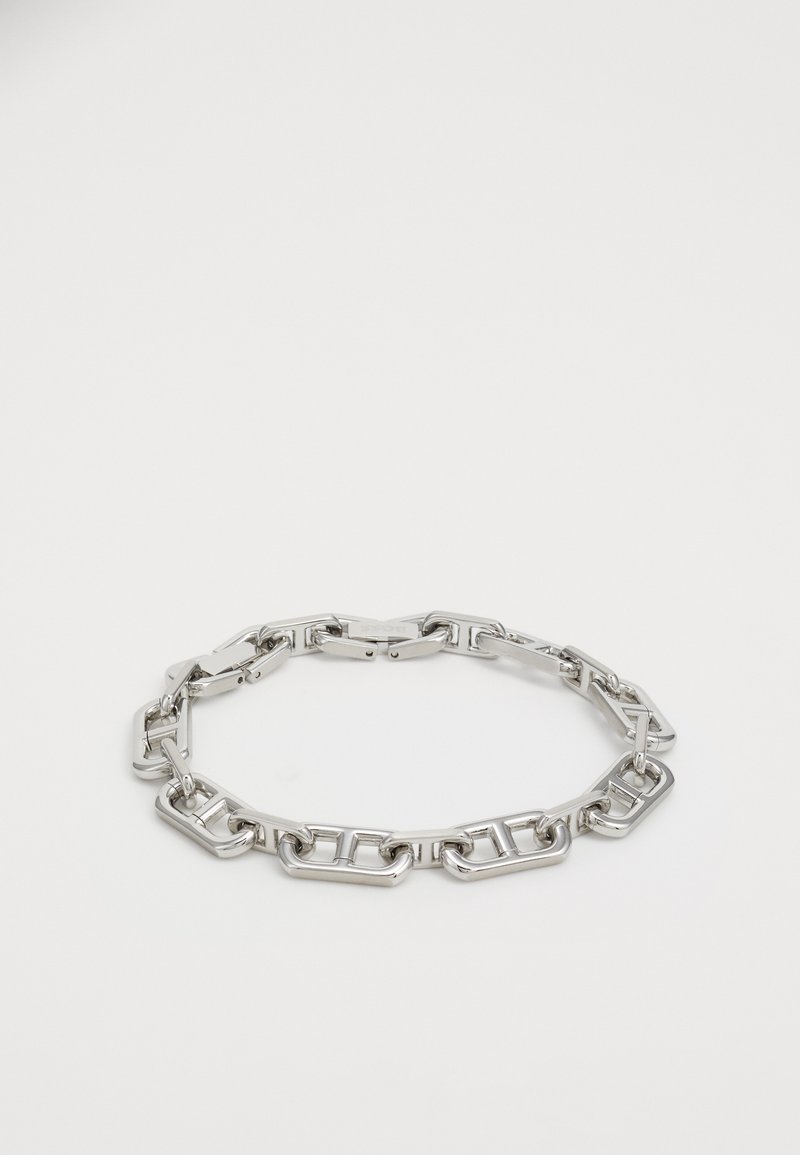 Strieborný náramok z reťaze so prepojenými obdĺžnikovými článkami, hladkým povrchom a bezpečným uzatváracím mechanizmom.