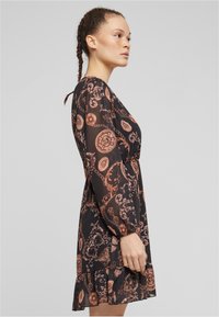 Rochie neagră cu mâneci lungi, având un model baroc aurie și cupru, tiv volanat și talie ajustată. Confecționată dintr-un material ușor și fluid.