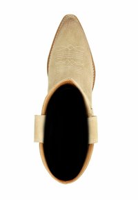 Beige suède enkellaars met pointed toe, decoratieve witte stiksels en een gladde leren rand rond de opening. Zool is tan.