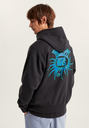 Zwarte hoodie met een groot turkooise zonnestraalgraphic en het "VANS"-logo op de achterkant. Heeft een ontspannen pasvorm en een trekkoordcapuchon.