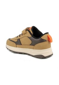 Sneaker color tortora e marrone con una fascia in velcro, suola in gomma, collare imbottito e un pratico tirante arancione sul tallone. Finitura in tessuto testurizzato.