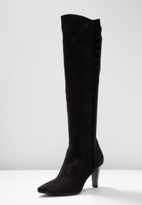 Schwarzes Wildleder-Stiefel über dem Knie mit spitzer Zehe, mittelhohem Absatz und Rüschendetails an der Seite. Glatte Textur mit eleganter Silhouette.