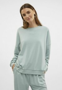 Lys blå sweatshirt lavet af blødt stof, med rund hals, sænket skuldre og ribbede manchetter. Casual pasform med sidelommer.