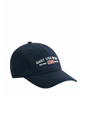 Marineblaue Baseballkappe mit gebogenem Schirm, bestickt mit dem Schriftzug "GANT USA SPORT" und einer kleinen amerikanischen Flagge auf der Vorderseite.