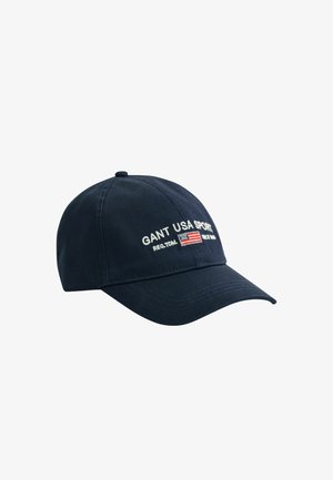 Marineblaue Baseballkappe mit gebogenem Schirm, bestickt mit dem Schriftzug "GANT USA SPORT" und einer kleinen amerikanischen Flagge auf der Vorderseite.
