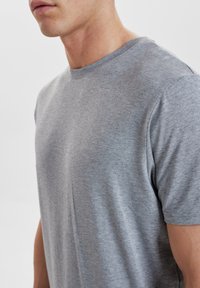 Gray cotton t-shirt featuring a crew neckline, short sleeves, and a smooth texture, with a fitted silhouette and no visible patterns or accents.