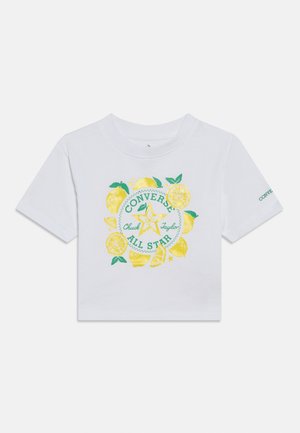 Bela majica s kratkimi rokavi, na kateri je rumeno-zelen grafični motiv limone in okrogel napis "CONVERSE Chuck Taylor ALL STAR".