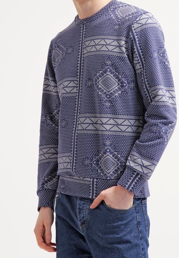 Felpa a maniche lunghe blu navy con motivi geometrici grigio chiaro, dotata di colletto rotondo e polsini a costine. Vestibilità casual, tessuto testurizzato.