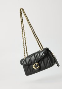 Sac à main en cuir matelassé noir avec une chaîne en métal doré et un fermoir. Il présente une fermeture à rabat et un accent logo à l'avant.