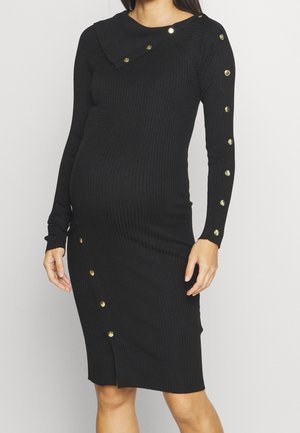 Schwarzes, geripptes Kleid mit langen Ärmeln, Knopfdetails entlang des Arms und breitem Kragen. Leicht taillierte Silhouette, knielanges Design.