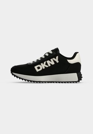 Baskets DKNY noir et blanc avec lacets blancs, logo DKNY marqué sur le côté et semelle extérieure dentelée pour la traction.