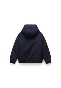 Veste à capuche bleu marine avec une finition lisse et mate. Poignets et ourlet élastiques, arborant un patch de logo sur la manche gauche. Vue de dos.