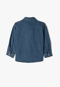 Jeansskjorta i mörkblått med klassisk krage, långa ärmar och knäppta manschetter. Har en rak skärning och mjuk känsla.