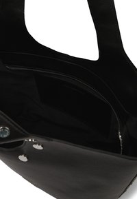 Sac fourre-tout en cuir noir avec deux poignées, intérieur doublé, poche zippée et fermeture magnétique, présentant un extérieur texturé et une finition lisse.