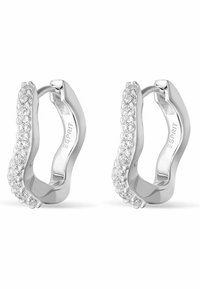 Orecchini a cerchio in argento con un design curvo, adornati con cristalli trasparenti lungo un bordo. Finitura liscia con una superficie lucida e riflettente.