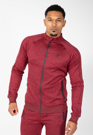 Rode sportieve zip-up jack met een textuurpatroon, zwarte accenten en ritszakken. Heeft een getailleerd ontwerp en geribbelde manchetten.