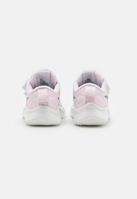 Zapatillas deportivas blancas con acentos rosas y detalles azules. La vista trasera muestra una suela texturizada y una lengüeta para tirar. Parte superior de tela suave con acolchado.