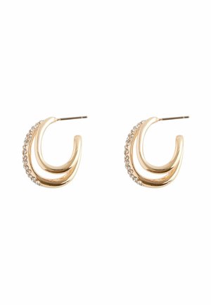 Orecchini a cerchio in tonalità oro con un design a doppia curvatura, caratterizzati da una fila di piccoli strass lungo un bordo. Chiusura con perno in metallo.