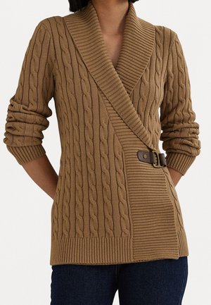 Suéter marrón de punto tipo trenza con cuello chal, diseño asimétrico y detalle de hebilla lateral. Presenta puños y dobladillo acanalados.