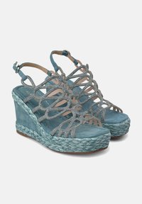 Sandalias de cuña en azul verdoso con suela de yute trenzado, decoradas con tiras ornamentales y acentos de strass. Textura suave de ante en la parte superior.