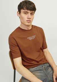 Rudas trumpas rankovės marškinėliai su apvalia iškirpte, ant krūtinės su baltu "JACK & JONES PREMIUM" užrašu. Pagaminti iš medvilnės, su lygia tekstūra.