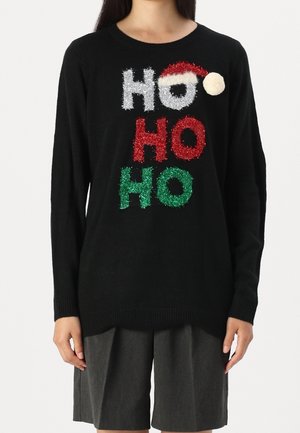 Pull noir avec le texte scintillant "HO HO HO" en blanc, rouge et vert, le "O" du haut portant un chapeau de Père Noël rouge et blanc avec un pompon.
