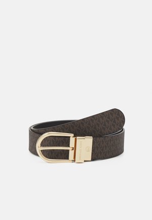 Bruine leren riem met goudkleurige gesp, met herhaald "MK" logopatroon en "Michael Kors" branding op de gesp.