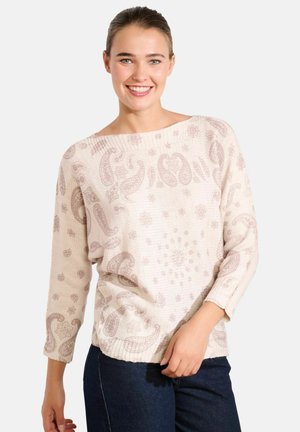 Maglione lavorato a maglia beige chiaro con motivi paisley e floreali, scollo ampio e maniche a tre quarti, abbinato a jeans scuri.