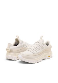 Lätta vita sportskor med texturerat tyg, snörningssystem, hälflik, vadderad sula och gummiyttersula från Vibram.