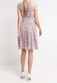 Světle růžové šaty bez rukávů s bílými puntíky. Lehký materiál, sešitý v pase, sukně do kolen. Zvýrazněné saténovým páskem.