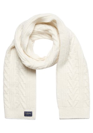 Écharpe en laine blanche tricotée avec motif torsadé et petite étiquette rectangulaire bleu foncé à une extrémité sur fond blanc.