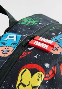 Ryggsäck med svart tyg som har färgglada superhjältars ansikten, inklusive Hulk och Captain America, samt röda dragkedjeremmar med texten "MARVEL".