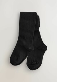 Chaussettes noires montantes en tissu lisse et texturé. Le design présente des orteils renforcés et une construction simple et sans coutures.