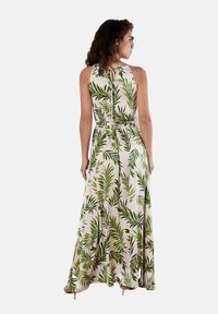 Maxikleid aus leichtem Stoff mit einem tropischen Blattmuster in Grüntönen auf einem hellen Hintergrund. Details mit Schlüsselloch-Ausschnitt am Rücken und taillierter Passform.