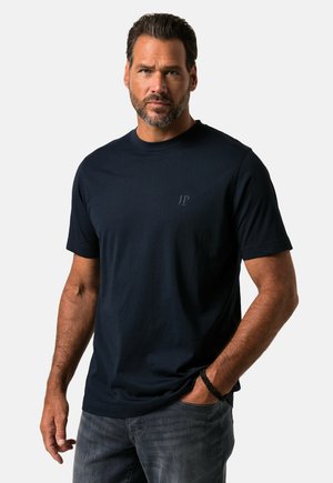 T-shirt blu navy a maniche corte in cotone. Presenta un piccolo logo JP tonale sul petto e una vestibilità rilassata, abbinato a jeans grigi.