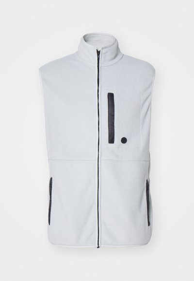 Lys grå fleecevest med høy krage, frontglidelås, svarte lommeakenter og sidelommer. Glatt tekstur med kontrasterende detaljer.