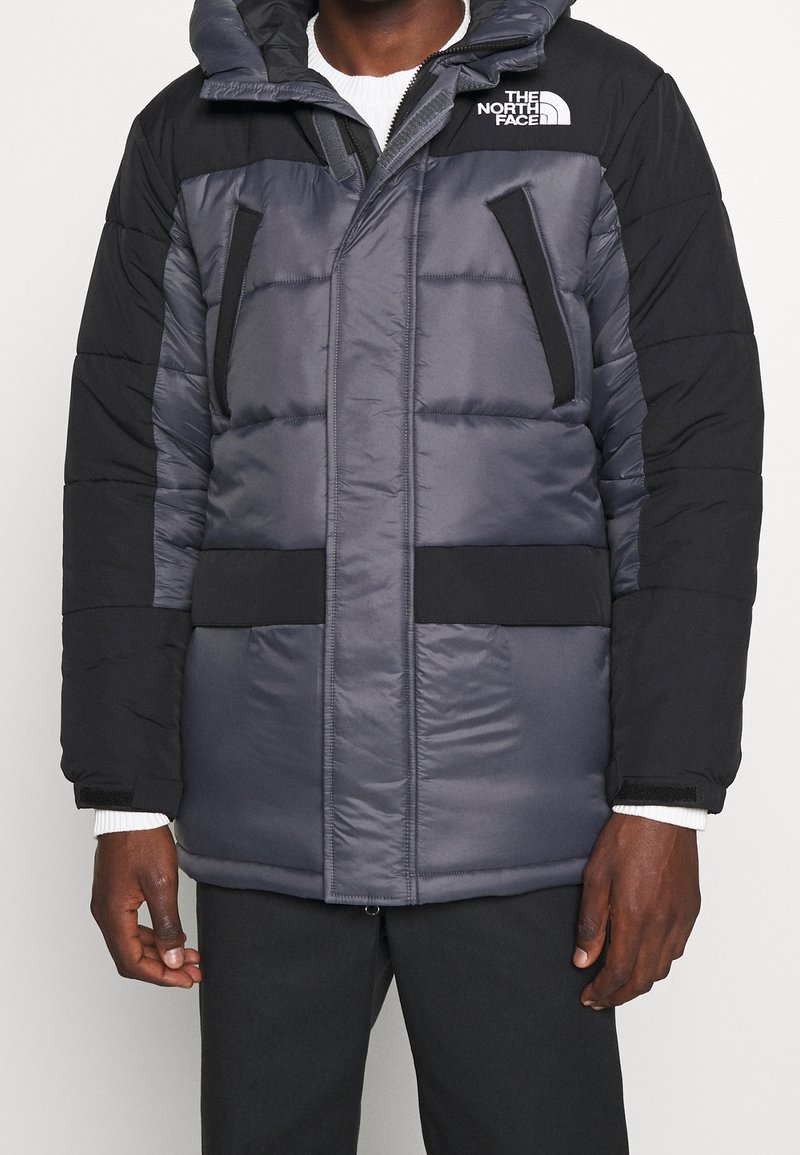 Pikowana kurtka parka w kolorze szarym i czarnym, z kapturem, zamkiem błyskawicznym, kieszeniami na piersi oraz miękką fakturą materiału. Marka na ramieniu.