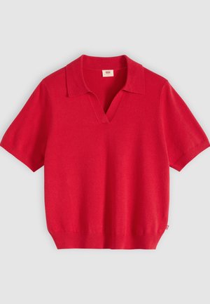 Červené pletené polo tričko s krátkými rukávy, výstřihem do V a žebrovaným lemem na světle šedém pozadí.