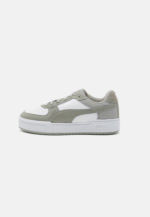 Niskie sneakersy z białymi i jasno szarymi panelami z zamszu i skóry, biała podeszwa i logo po boku, widziane od zewnętrznej strony.