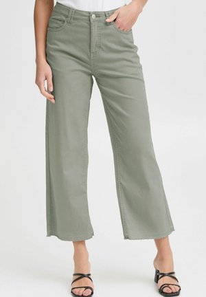 Pantalons larges de couleur vert clair, fabriqués dans un tissu à texture lisse, avec une taille haute, des passants de ceinture et des poches avant.