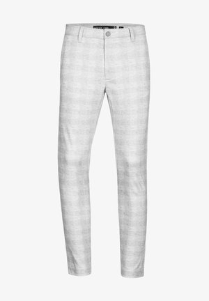 Pantaloni grigi slim fit con sottili righe verticali, dotati di chiusura a bottone e passanti per cintura, abbinati a sneakers bianche e a un maglione nero.