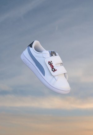 Baskets blanches et bleues pour enfants avec des sangles velcro présentant un motif de voiture rouge, sur un fond de ciel nuageux.
